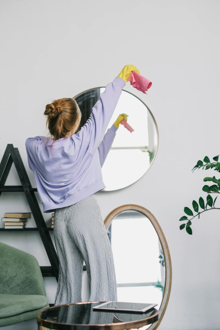 Woman Holding a Pink Towel Standing In Front of a Mirror