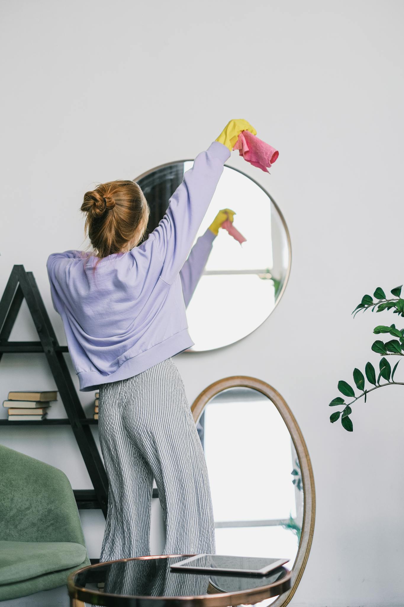 Woman Holding a Pink Towel Standing In Front of a Mirror